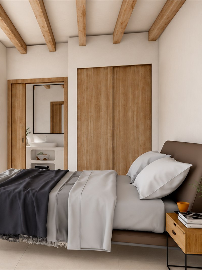 Dormitorio principal con armarios de madera de suelo a techo y paso abierto al baño en suite, con el lavabo y el espejo al fondo