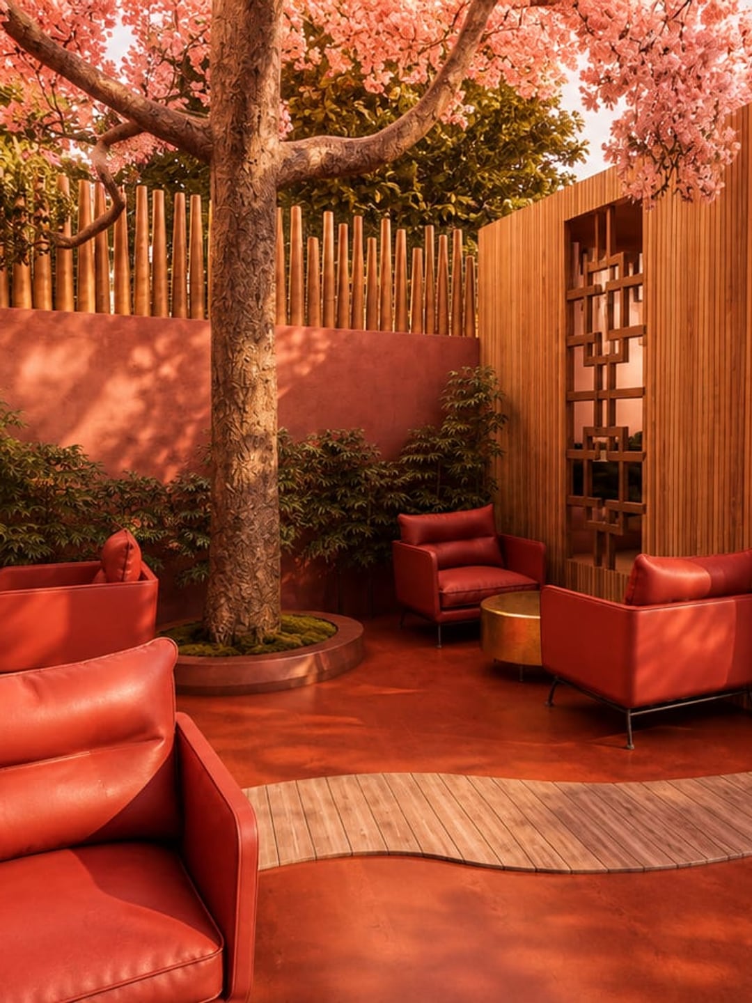 El cerezo en su alcorque de musgo contra la valla de bambú, con el sendero de tarima, los sillones rojos y la celosía calada del volumen de madera